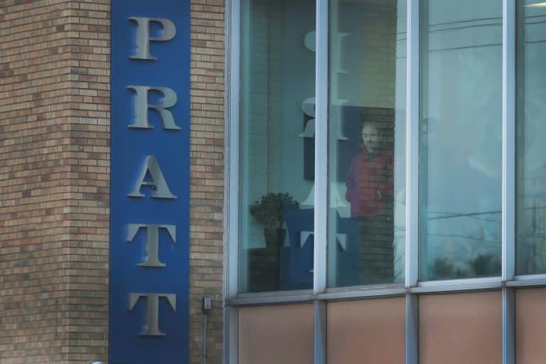 Workers look out an office window at the Henry Pratt Company, on the outskirts of Chicago, after the shooting which witnesses blamed on a disgruntled employee