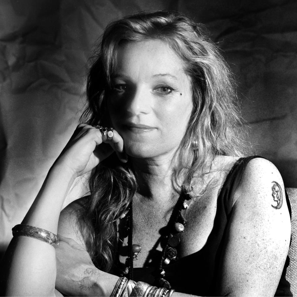 A black-and-white photo of a woman in a dark tank top posing for a portrait