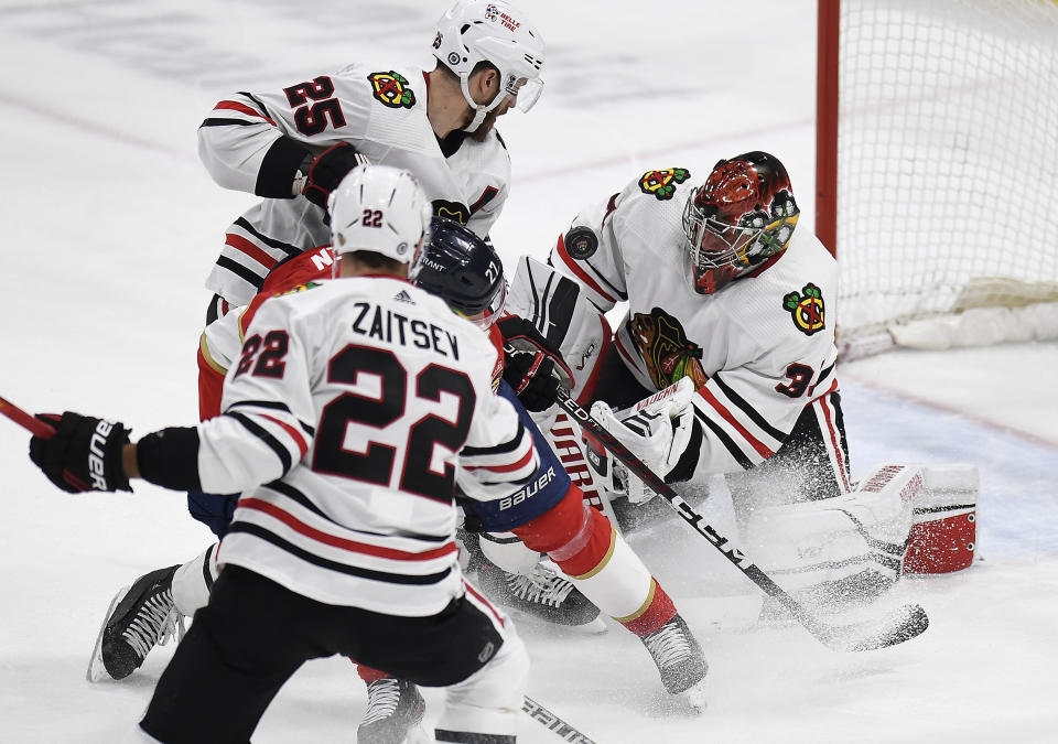 Chicago Blackhawks goaltender Petr Mrazek (34) stops the puck shot by Florida Panthers center Eetu Luostarinen (27) during the second period of an NHL hockey game, Friday, March 10, 2023, in Sunrise, Fla. (AP Photo/Michael Laughlin)