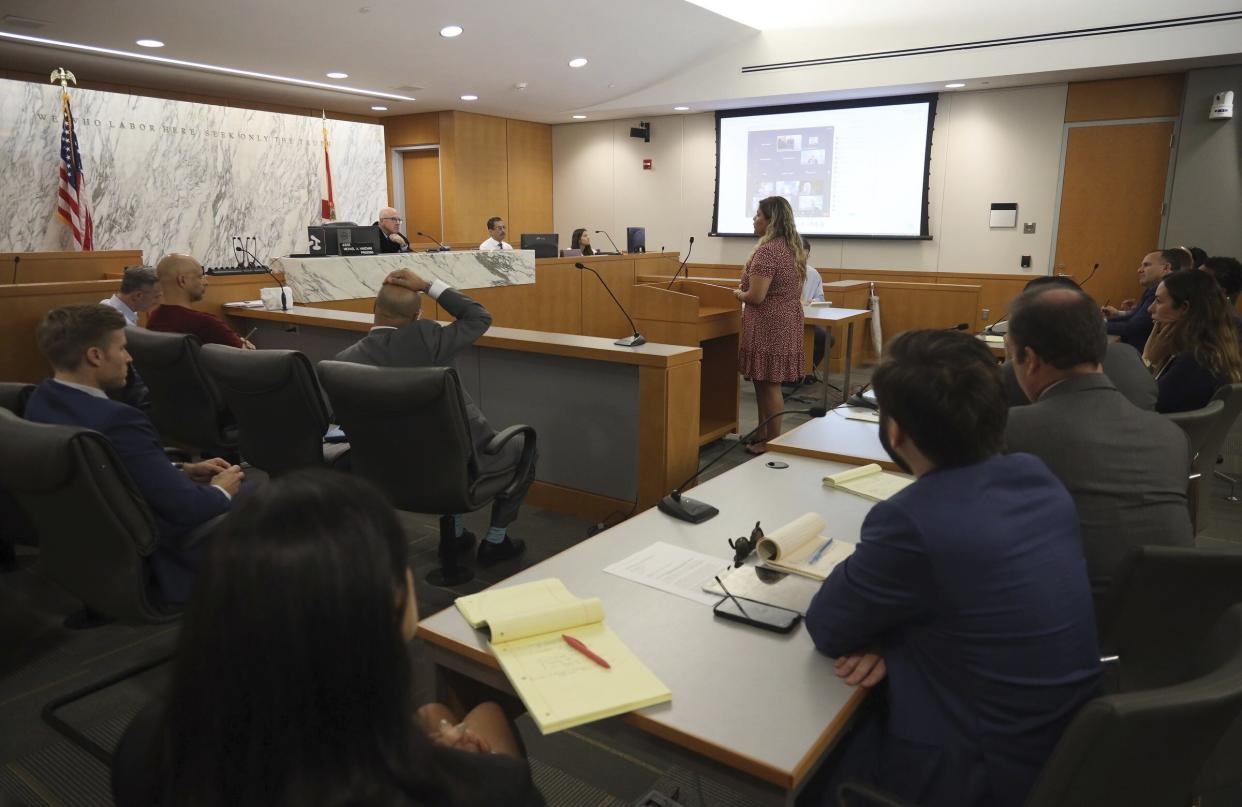 Yadira Santos, center, a victim of the Champlain Towers South collapse, speaks to Judge Michael Hanzman about her wishes for the site, during a hearing Wednesday, July 21, 2021, in Miami. Hanzman said victims and families who suffered losses in the collapse of the 12-story oceanfront Florida condominium will get a minimum of $150 million in compensation initially. (Carl Juste/Miami Herald via AP, Pool)