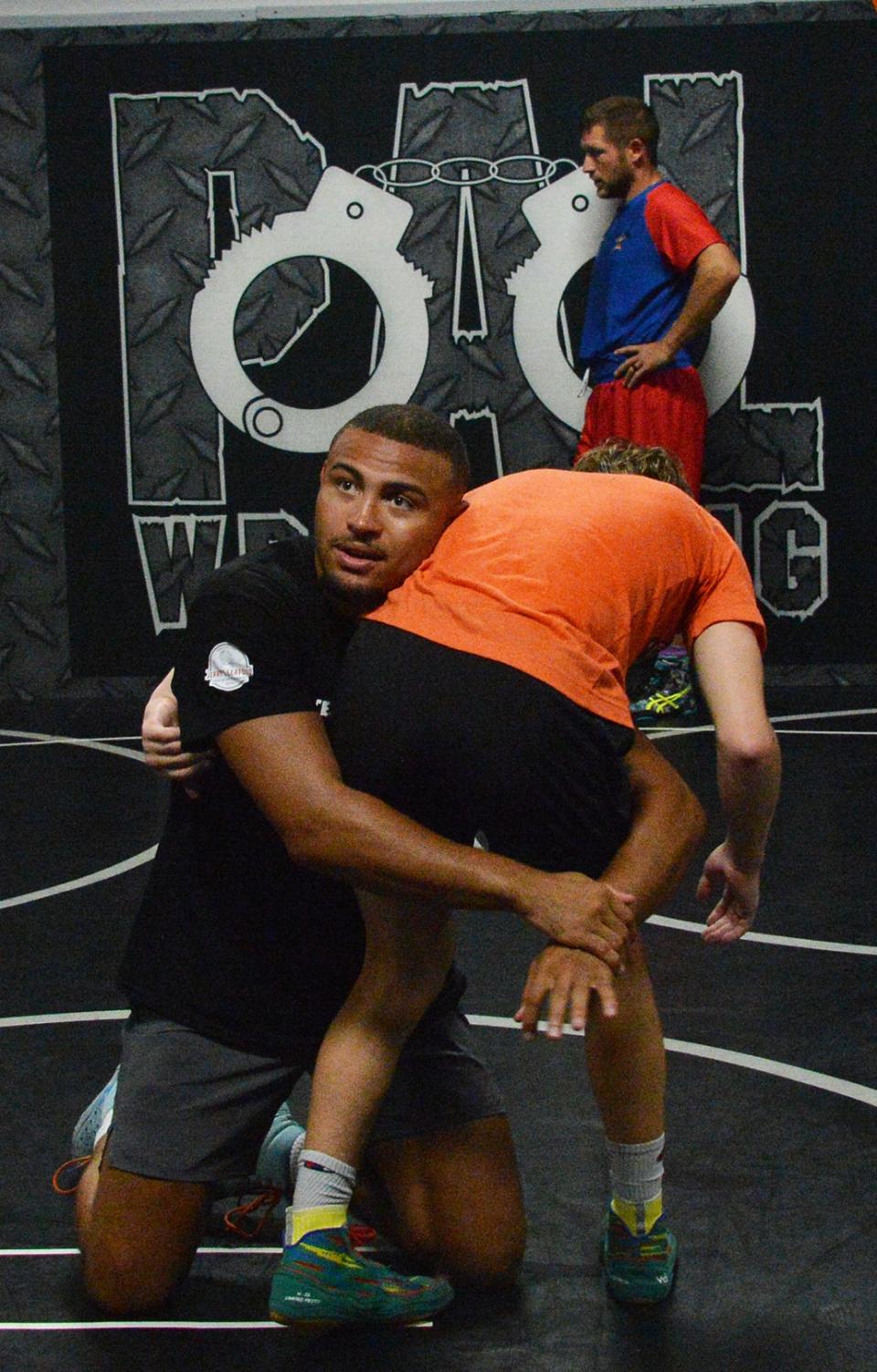 Hagerstown's Aaron Brooks, a three-time NCAA wrestling champion for Penn State, demonstrates a technique during a PAL wrestling camp Saturday at Fairgrounds Park.