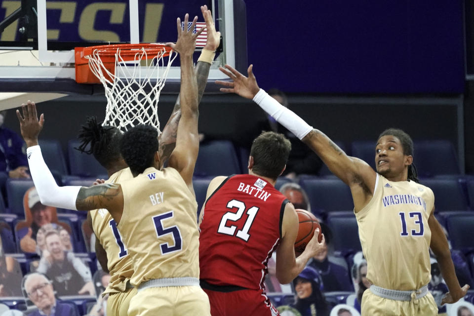 Washington forward Hameir Wright (13) and guard Jamal Bey (5) try to block a shot by Utah forward Riley Battin (21) during the first half of an NCAA college basketball game, Sunday, Jan. 24, 2021, in Seattle. (AP Photo/Ted S. Warren)