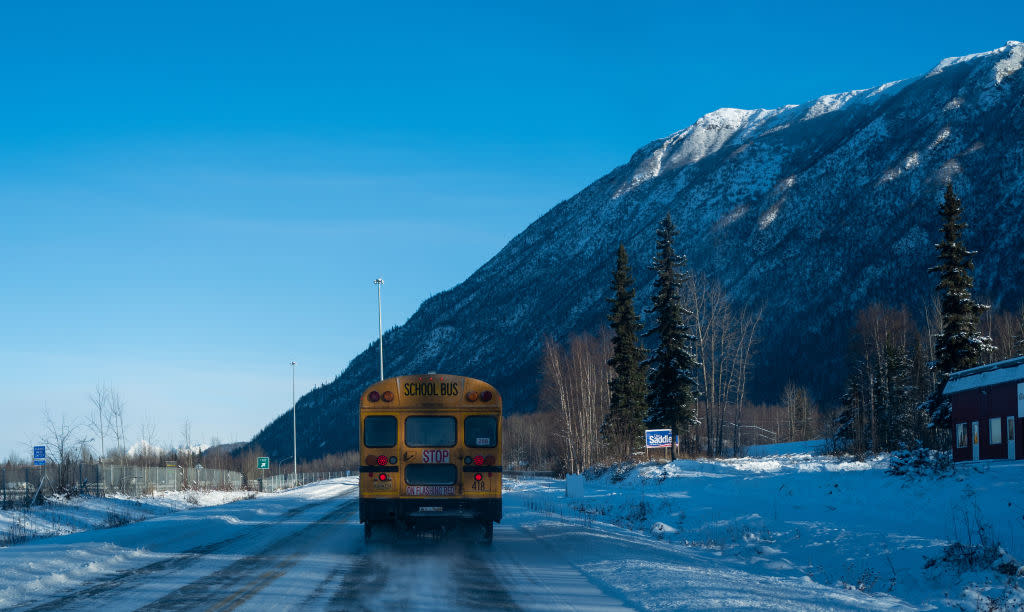 A school bus drives along a snow covered road on Nov. 4, 2022, in Eagle River, Alaska. (Photo by Spencer Platt/Getty Images)