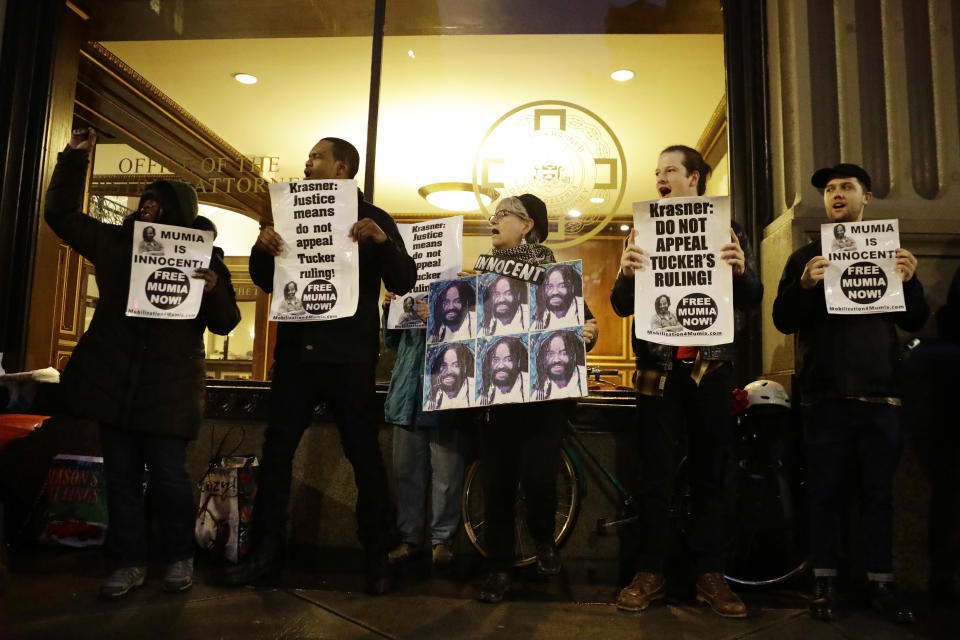 Demonstrators in support of Mumia Abu-Jamal stand outside the offices of District Attorney Larry Krasner, Friday, Dec. 28, 2018, in Philadelphia. A judge issued a split ruling Thursday that grants Abu-Jamal another chance to appeal his 1981 conviction in a Philadelphia police officer's death. (AP Photo/Matt Slocum)