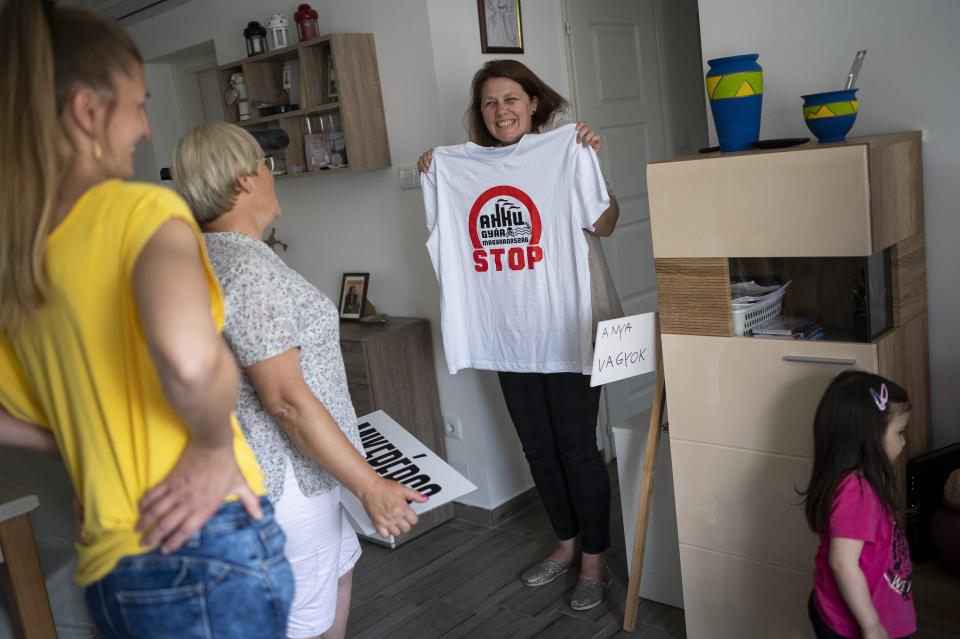 Eva Kozma shows her T-shirt she made for a demonstration against a factory to produce batteries for electric vehicles built by China-based Contemporary Amperex Technology Co. Limited (CATL) near Debrecen, Hungary on Tuesday, May 23, 2023. Residents, environmentalists and opposition politicians are worried that the factory will exacerbate existing environmental problems and use up the country's precious water supplies. (AP Photo/Denes Erdos)