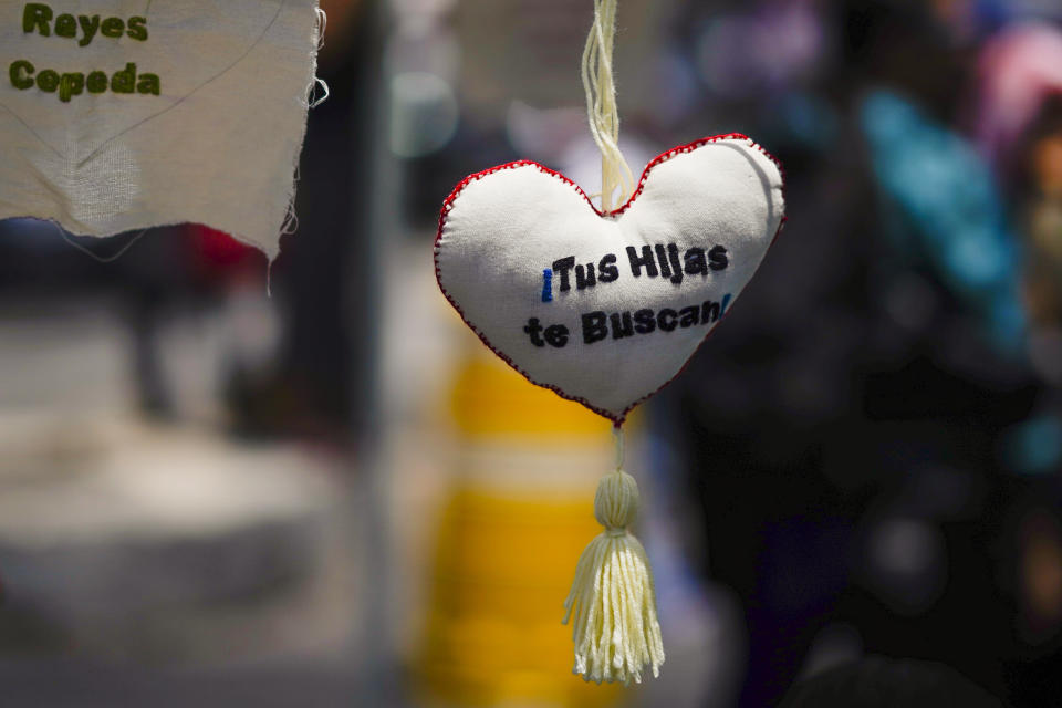 An embroidered heart with a message that reads in Spanish: "Your daughters are looking for you" hangs from a tent during a gathering of mostly mothers demanding the government do more to locate their loved ones, marking International Day of the Disappeared, in Mexico City, Wednesday, Aug. 30, 2023. Mothers of some of 111,000 people who have disappeared in Mexico over decades of violence, most believed to have been abducted by drug cartels or kidnapped by gangs, gathered on Wednesday on Reforma Avenue. (AP Photo/Eduardo Verdugo)