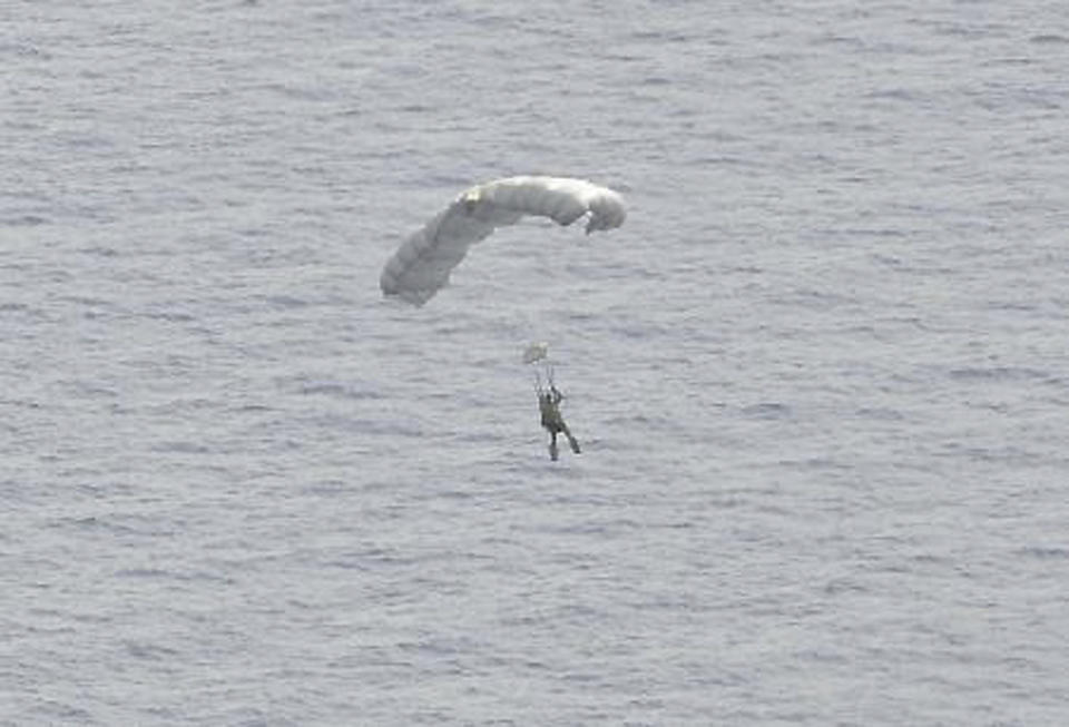 In this May 3, 2014, image provided by the U.S. Air Force, a U.S. Air Force Airman parachutes into the Pacific Ocean to aid two critically injured sailors aboard a Venezuelan fishing boat. The Venezuelan fishing boat found the sailors floating in a raft Friday afternoon after their vessel sank off the coast of Mexico, said Sarah Schwennese, spokeswoman at the Davis-Monthan Air Force Base in Tucson. (AP Photo/U.S. Air Force, Staff Sgt. Adam Grant)