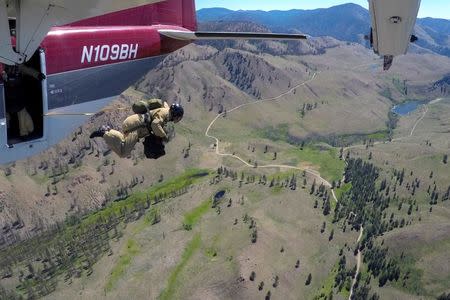 A smokejumper leaps from an airplane during a training flight above Winthrop, Washington, U.S., June 30, 2016. REUTERS/David Ryder