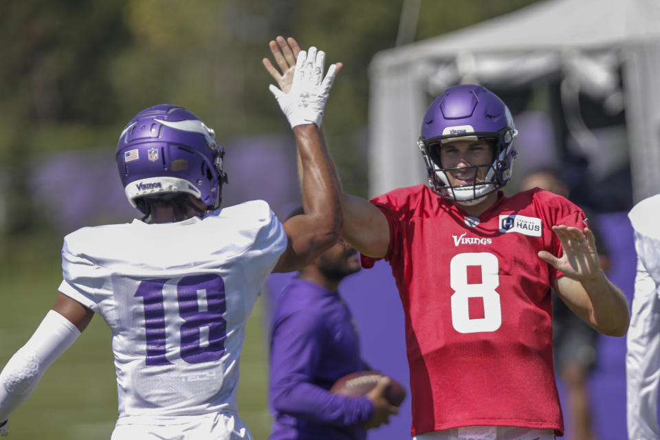 Minnesota Vikings' Kirk Cousins (8) celebrates with Vikings receiver Justin Jefferson (18) at the NFL football team's practice facility in Eagan, Minn., Monday, Aug. 1, 2022. (AP Photo/Andy Clayton-King)