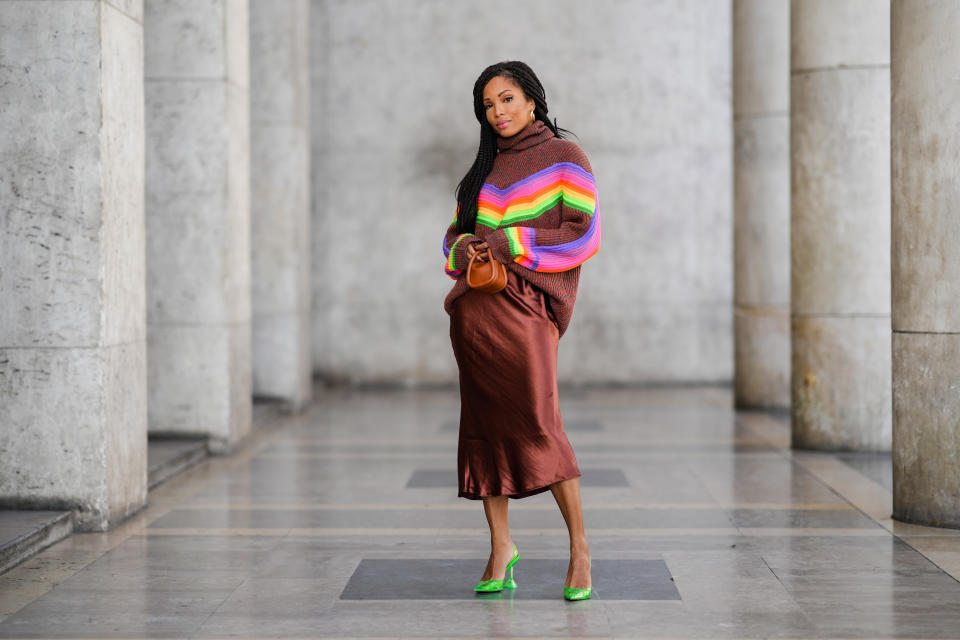 woman in brown midi skirt and colorful sweater