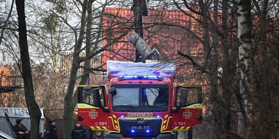 Rescuers remove the warhead of an unexploded rocket from a residential yard in Kyiv's Shevchenkivskyi district