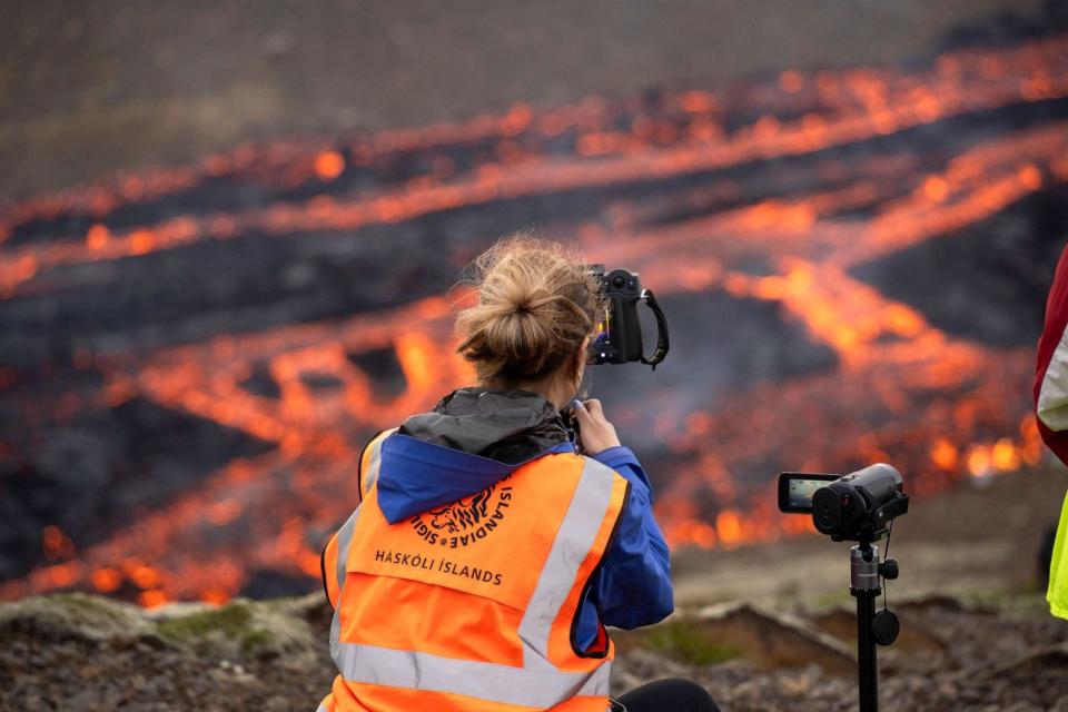 PHOTO: Scientists and students of the department of Geology of the University of Iceland, observe the eruption and take measurements of the Fagradalsfjall volcano near the Litli-Hrutur mountain, southwest of Reykjavik, Iceland, July 10, 2023. (Marco Di Marco/AP)