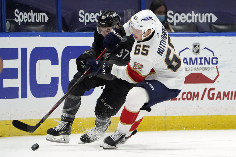 Florida Panthers defenseman Markus Nutivaara (65) takes the puck from Tampa Bay Lightning center Yanni Gourde (37) during the second period of an NHL hockey game Saturday, April 17, 2021, in Tampa, Fla. (AP Photo/Chris O'Meara)