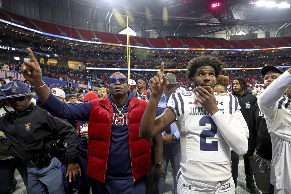 Jackson State head coach Deion Sanders, left, and quarterback Shedeur Sanders (2) point to the band after their overtime loss to North Carolina Central in the Celebration Bowl NCAA college football game, Saturday, Dec. 17, 2022, in Atlanta.(Jason Getz/Atlanta Journal-Constitution via AP)