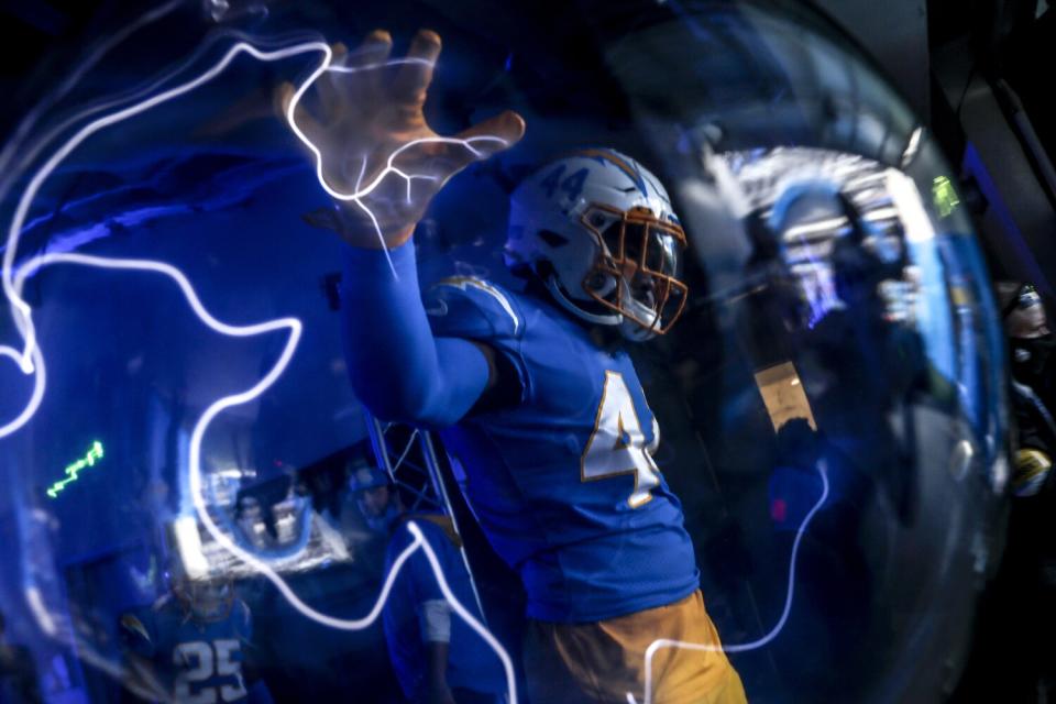 A football player touches a lightning orb.