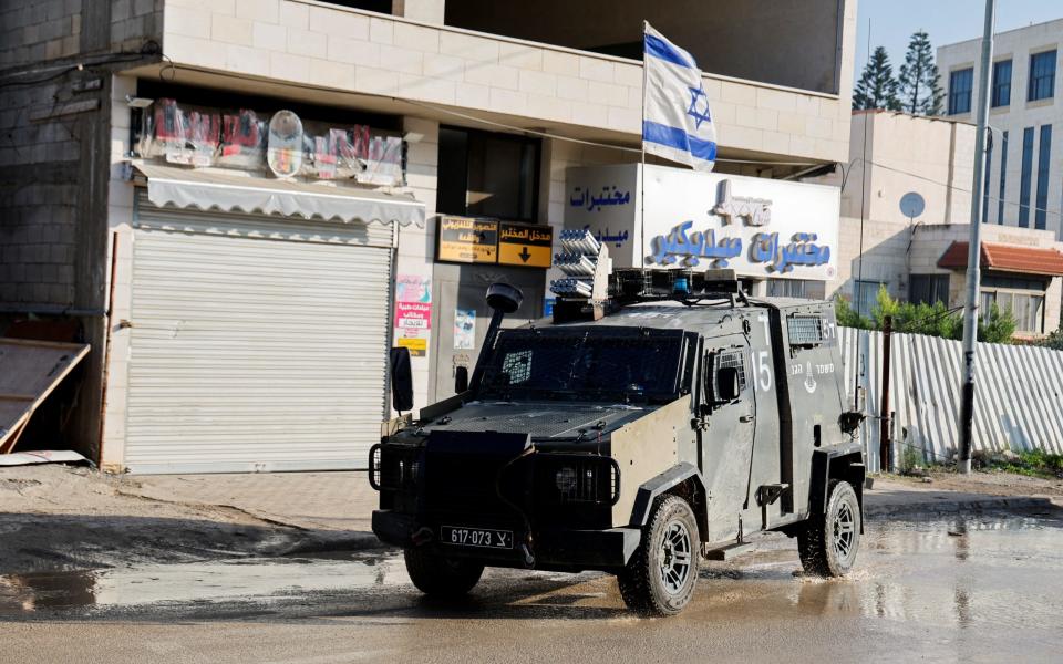 An Israeli military vehicle with an Israeli flag on top in Jenin