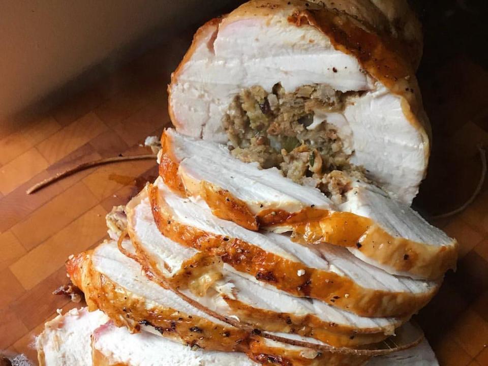 Turkey stuffed with a stuffing center sliced on a wood cutting board