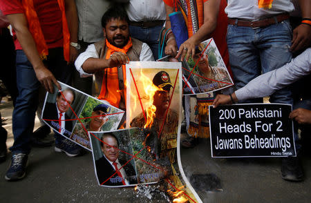 Members of Hindu Sena, a right wing Hindu group, burn posters of Pakistan's Prime Minister Nawaz Sharif and Pakistan's army chief Lieutenant General Qamar Javed Bajwa during a protest in New Delhi, India, May 2, 2017, against the killing of two Indian soldiers who were patrolling the de facto border in the disputed Kashmir region on Monday. REUTERS/Adnan Abidi