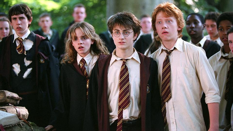 Hermione, Harry, and Ron from "Harry Potter" in school uniforms, looking surprised