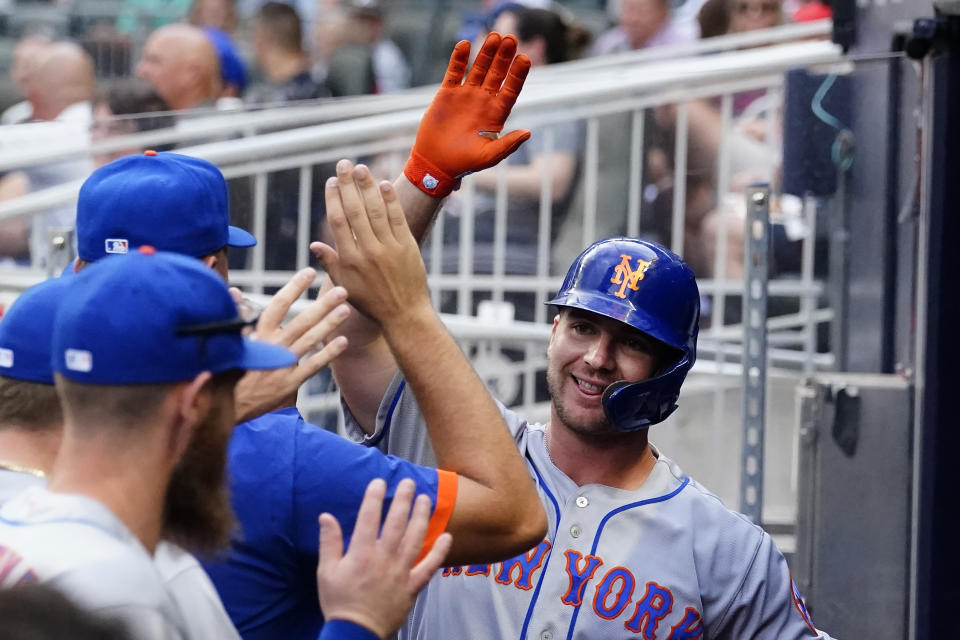 New York Mets' Pete Alonso, right, celebrates in the dugout after hitting a two-run home run in the first inning of the team's baseball game against the Atlanta Braves on Wednesday, June 30, 2021, in Atlanta. (AP Photo/John Bazemore)