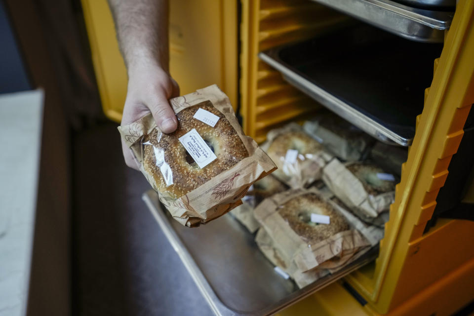 Eli Chitrik from Turkey shows bagel sandwiches at his hotel room in Doha, Qatar, Monday, Nov. 28, 2022. Stored into bright orange cases in Rabbi Eli Chitrik’s hotel room are bagels stuffed with vegetables. The labels declare the sandwiches kosher, or in compliance with Judaism’s set of dietary regulations. Freshly baked, they are made in Qatar at a designated kitchen, set up to feed Jewish World Cup visitors who want to keep kosher during the tournament. (AP Photo/Moises Castillo)