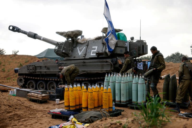 Soldados israelíes preparan proyectiles cerca de una unidad de artillería móvil, en medio del actual conflicto entre Israel y el grupo islamista palestino Hamás