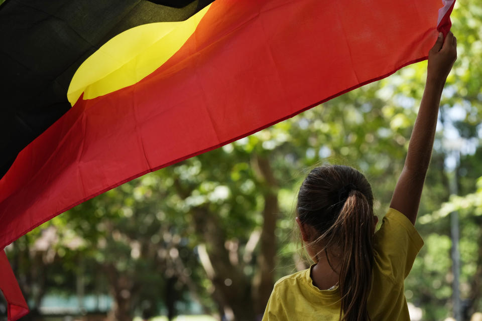 A young girl holds an Aboriginal flag at an Indigenous Australians protest during Australia Day in Sydney, Friday, Jan. 26, 2024. Thousands of Australians protest on the anniversary of British colonization of their country amid fierce debate over whether the increasingly polarizing national holiday dubbed 'Australia Day' should be moved to another date. (AP Photo/Rick Rycroft)