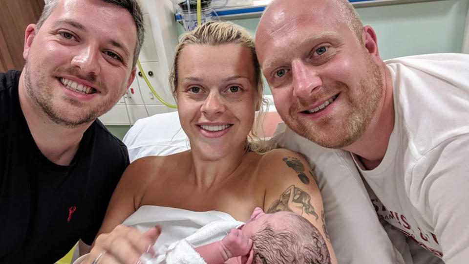 Pictured with baby Harper Elizabeth Smith, surrogate mother Chapelle Cooper, centre, and proud parents Michael Smith, left. and Scott Stephenson, right. Source: Facebook