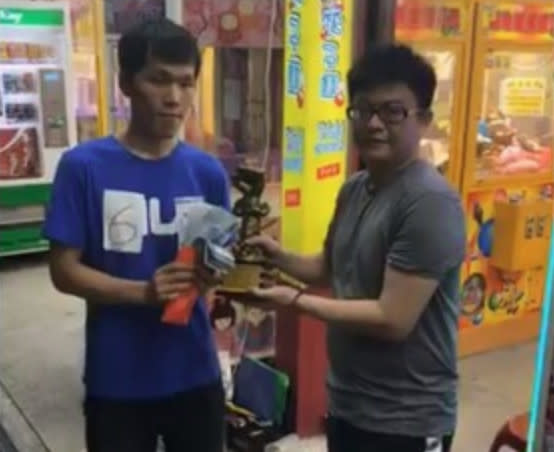 現年26歲來自台北市的徐士傑（左）僅以170元就成功夾取2盒市價1200元的藍芽耳機，打敗其他38名好手勝出，得到10萬元獎金和冠軍獎座！（圖片翻攝員林夾子園FB）