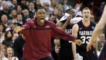 Harvard players rush from the bench to greet teammates after beating Cincinnati in the second round of the NCAA college basketball tournament in Spokane, Wash., Thursday, March 20, 2014. Harvard won 61-57. (AP Photo/Elaine Thompson)