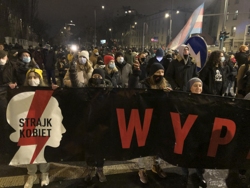 People march near the ruling Law and Justice party headquarters in Warsaw, Poland Wednesday Jan. 27, 2021 to protest after the country's top court on Wednesday confirmed its highly divisive ruling that will further tighten the predominantly Catholic nation's strict anti-abortion law. The Constitutional Tribunal published the justification of its decision, which means it can now be officially printed and take immediate effect. (AP Photo/Czarek Sokolowski)