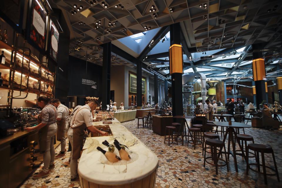 In this photo taken on Tuesday, Sept. 4, 2108, a view of the Starbucks store in Milan, Italy. Starbucks opens its first store in Italy Friday, betting that premium brews and novelties like a heated marble-topped coffee bar will win patrons in a country fond of its espresso rituals. Decades ago, Milan’s coffee bars had inspired the chain’s vision. Starbucks hopes clients will linger at Starbucks Reserve Roastery, where they can watch beans being roasted, sip Reserve coffee or have cocktails at a mezzanine-level bar in a cavernous space that once was a post office near the city’s Duomo, or cathedral. (AP Photo/Luca Bruno)