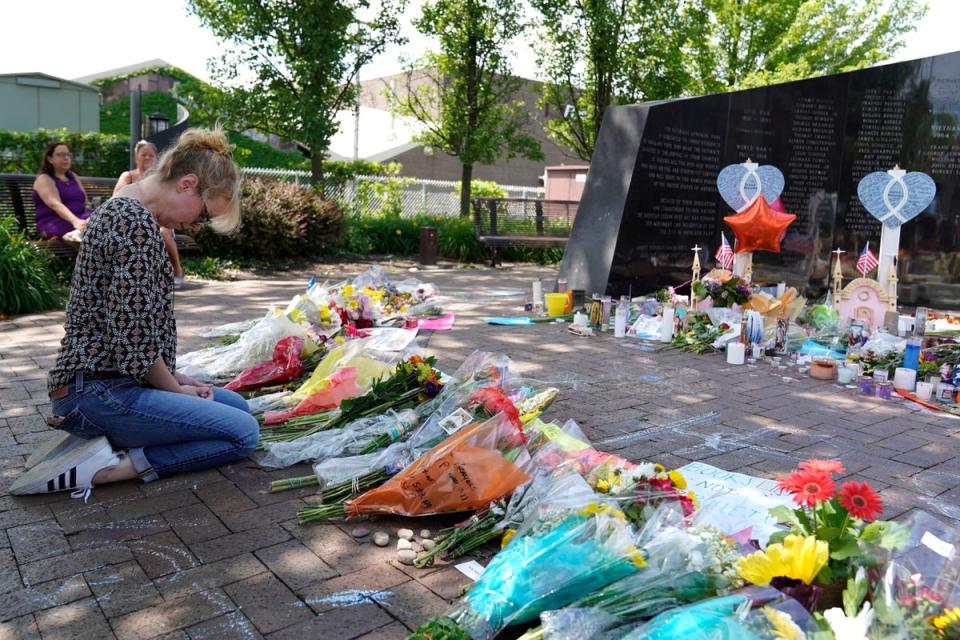 A visitor prays at a memorial to the seven people killed and others injured in the Fourth of July shooting (Copyright 2022 The Associated Press. All rights reserved.)