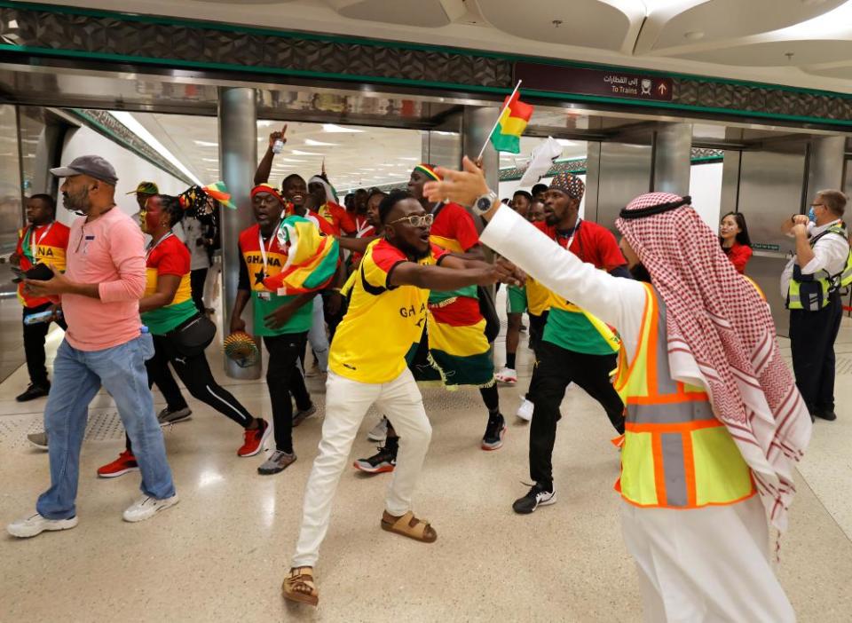 Singing and dancing Ghana fans are pointed in the right direction to the stadium by officials at Education City metro station before the Ghana v South Korea match.