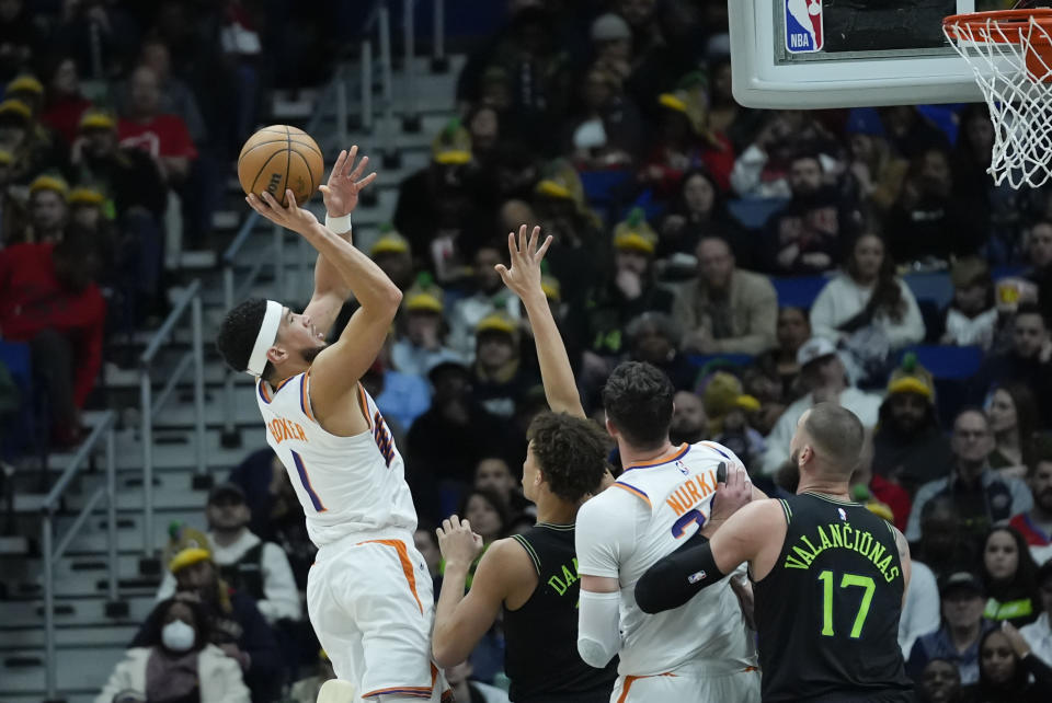 Phoenix Suns guard Devin Booker (1) shoots against New Orleans Pelicans guard Dyson Daniels in the first half of an NBA basketball game in New Orleans, Friday, Jan. 19, 2024. (AP Photo/Gerald Herbert)