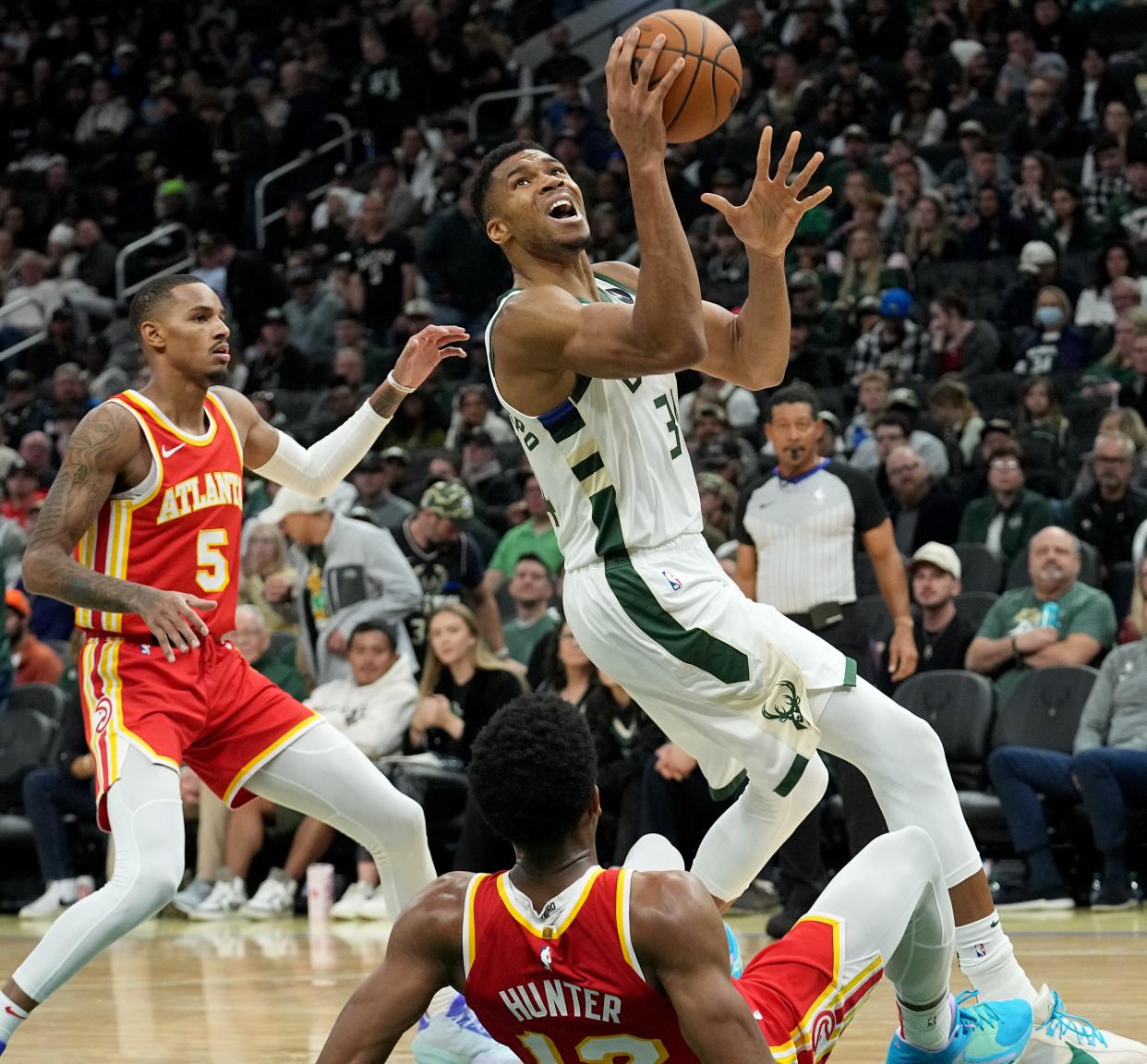 Milwaukee Bucks forward Giannis Antetokounmpo (34) fouls Atlanta Hawks forward De'Andre Hunter (12) during the second half of their game Sunday, October 29, 2023 at Fiserv Forum in Milwaukee, Wisconsin. The Atlanta hawks beat the Milwaukee Bucks 127-110.