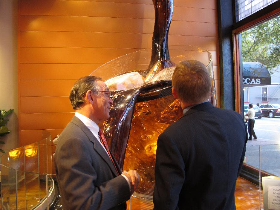 Heaven Hill Distilleries President Max L. Shapira, left, chats next to the centerpiece display in the lobby of The Evan Williams Bourbon Experience tourism attraction on Nov. 14, 2013, in downtown Louisville, Ky. The newly opened center is just steps from where pioneer distiller Evan Williams set up his commercial stills two centuries ago. (AP Photo/Bruce Schreiner)