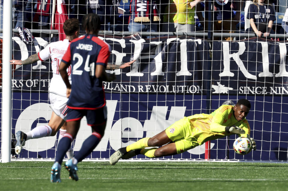 Toronto FC goalkeeper Sean Johnson, right, makes a save in the first half of an MLS soccer match against the New England Revolution, Sunday, March 3, 2024, in Foxborough, Mass. (AP Photo/Mark Stockwell)