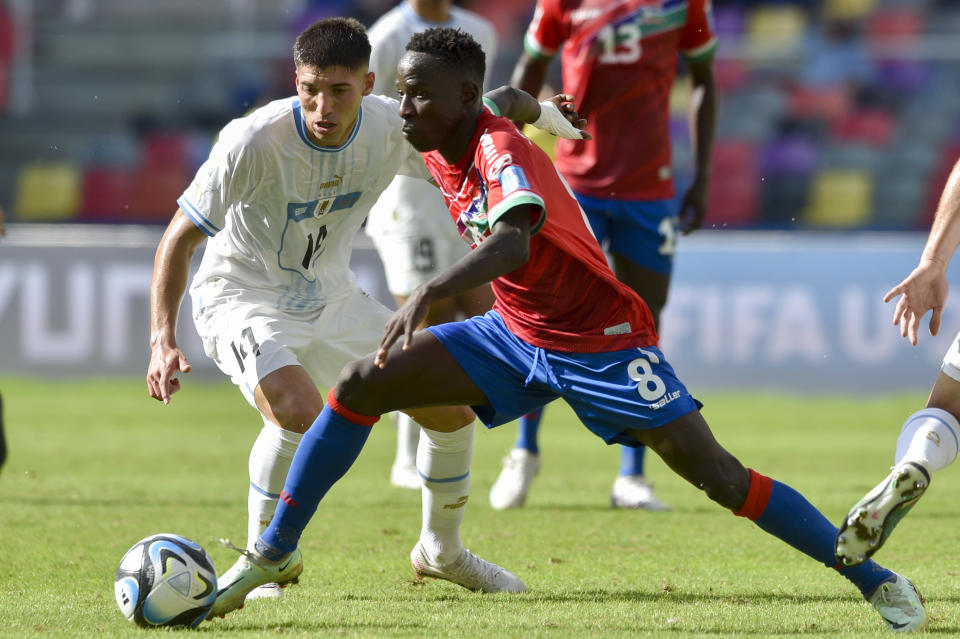 Gambia's Salifu Colley controls the ball under the watch of Uruguay's Juan De Los Santos during a FIFA U-20 World Cup round of 16 soccer match at the Madre de Ciudades stadium in Santiago del Estero, Argentina, Thursday, June 1, 2023. (AP Photo/Gustavo Garello)