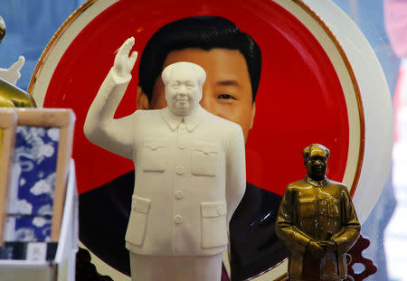 Sculptures of the late Chinese Chairman Mao Zedong are placed in front of a souvenir plate featuring a portrait of Chinese President Xi Jinping at a shop next to Tiananmen Square in Beijing, China, March 1, 2018. REUTERS/Jason Lee