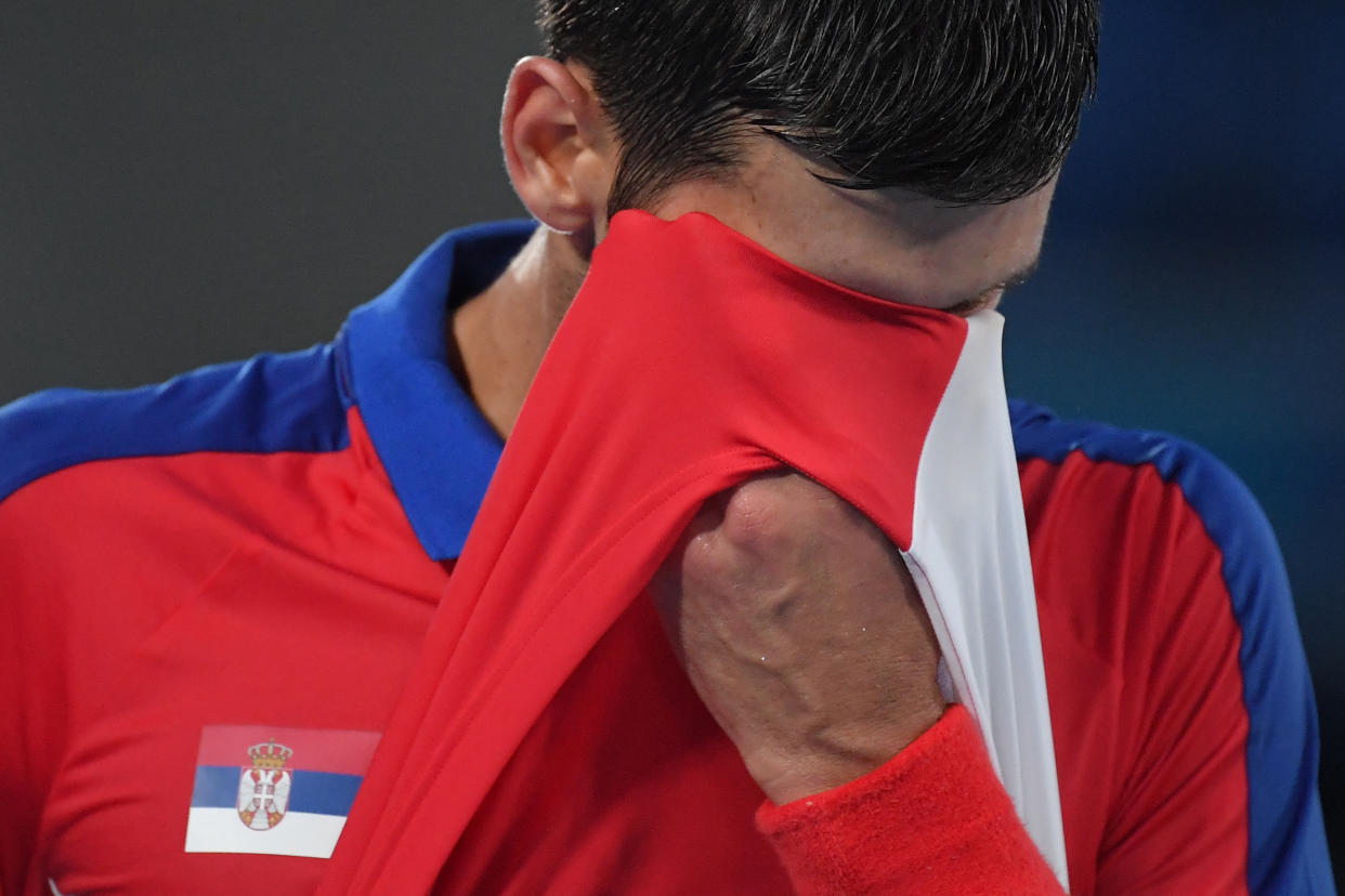 Serbia's Novak Djokovic wipes his face as he competes against Germany's Alexander Zverev during their Tokyo 2020 Olympic Games men's singles semifinal tennis match at the Ariake Tennis Park in Tokyo on July 30, 2021. (Photo by Tiziana FABI / AFP) (Photo by TIZIANA FABI/AFP via Getty Images)