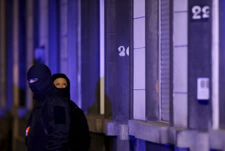 Masked Belgian police secure the entrance to a building in Schaerbeek during police operations following Tuesday's bomb attacks in Brussels, Belgium, March 25, 2016. REUTERS/Christian Hartmann