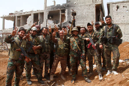 Soldiers loyal to Syria's President Bashar al Assad gesture outside Yarmouk Palestinian camp in Damascus, Syria May 2, 2018. SANA/Handout via REUTERS