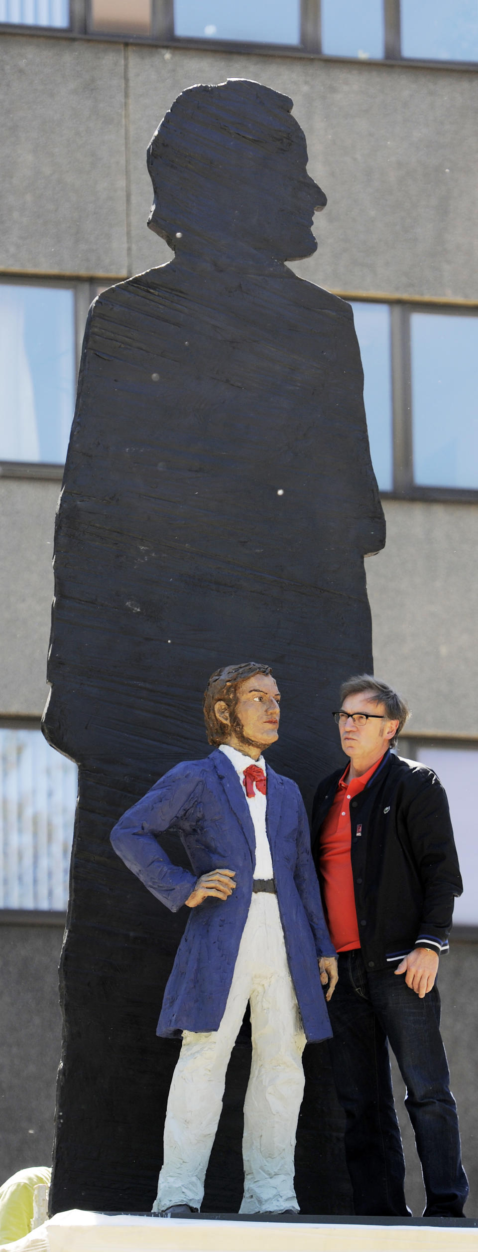 FILE - In this May 15, 2013 file photo German artist Stephan Balkenhol, right, stands besides a part of his Richard Wagner Monument during the installation in Leipzig, central Germany. The Wagner monument will be unveiled Wednesday, May 22, 2013, to celebrate the German composer's 200th birthday. It shows a young Wagner overshadowed by his older, famous self. Some of Wagner's works will be performed later in the day in Bayreuth, where the composer's descendants organize an annual music festival. (AP Photo/Jens Meyer, File)