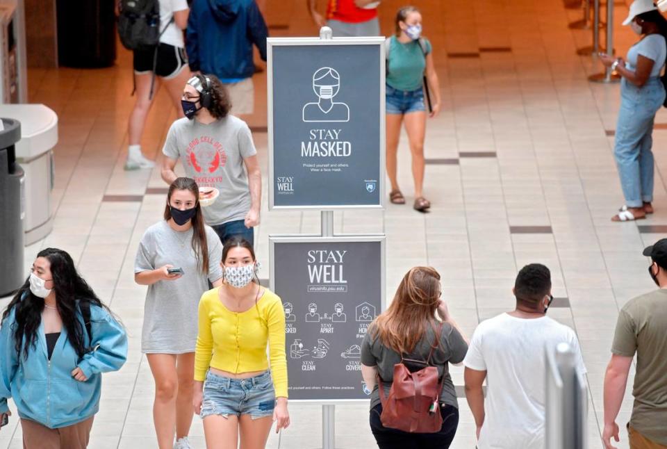 Penn State students walk through the HUB-Robeson Center around signs that remind students to wear a mask on the first day of classes for the fall 2020 semester on Aug. 24, 2020.