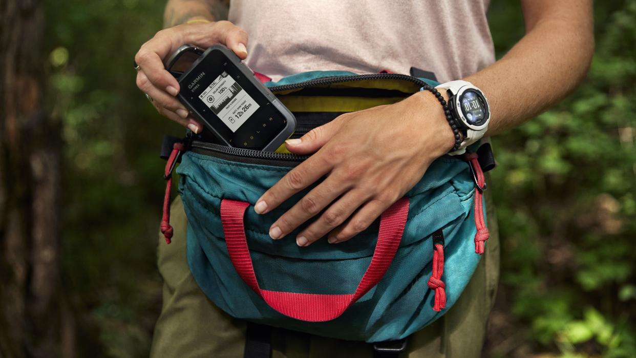  Woman using Garmin eTrex Solar device while hiking. 