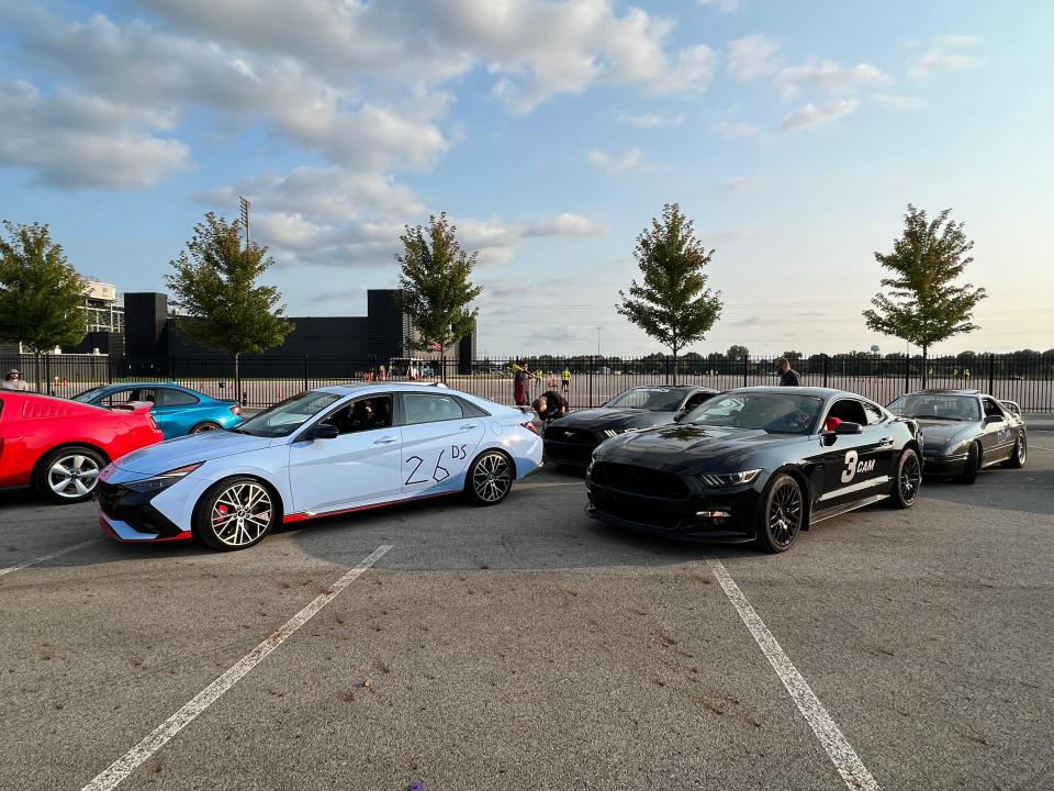 A 2022 Elantra N next to a Ford Mustang on the grid waiting to race.