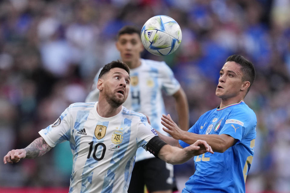 Argentina's Lionel Messi, left, challenges for the ball with Italy's Giacomo Raspadori during the Finalissima soccer match between Italy and Argentina at Wembley Stadium in London , Wednesday, June 1, 2022. (AP Photo/Matt Dunham)