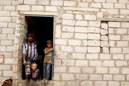 People displaced from the Red Sea port city of Hodeidah stand at the door of a host family's house where they live on the outskirts of Sanaa, Yemen July 10, 2018. REUTERS/Khaled Abdullah