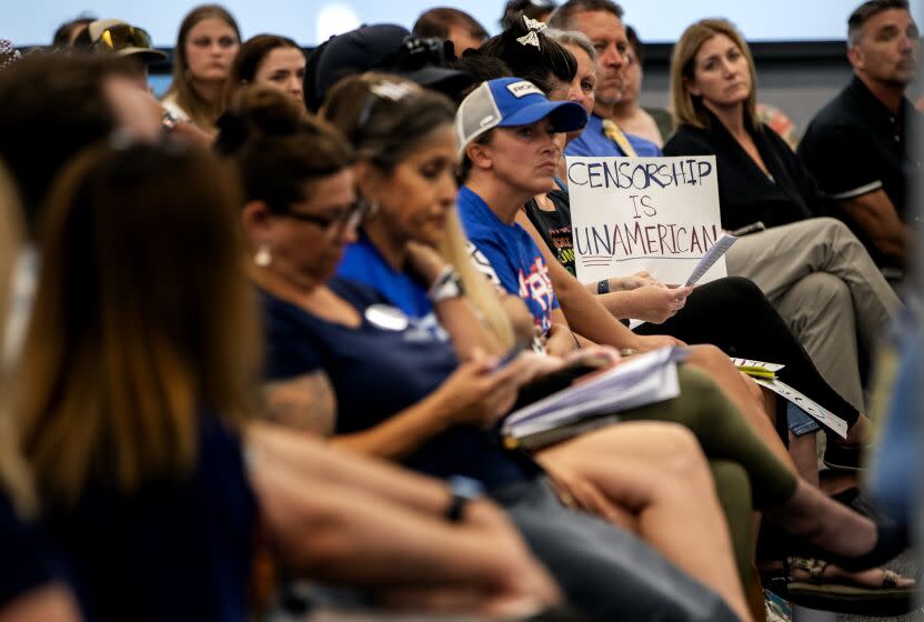 TEMECULA, CA - JULY 18, 2023: An audience member hold sup a sign that says "Censorship is UnAmerican" during a school board meeting on July 18, 2023 in Temecula, California. The conservative majority on the school board is at the center of a debate with Gov. Gavin Newsom who has threatened to fine the board over $1 million because of their resistance to include a lesson involving Harvey Milk.(Gina Ferazzi / Los Angeles Times)